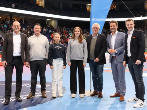 Gruppenbild in einer Sportarena.